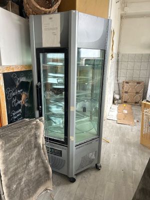 une photo d'une cuisine avec un réfrigérateur et une chaise