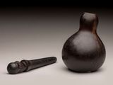 an image of a small vase with a hammer in front of it