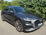 the audi qx is parked on the side of the road