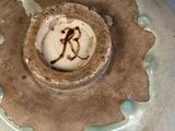 a ceramic bowl with a brown and green decoration on it