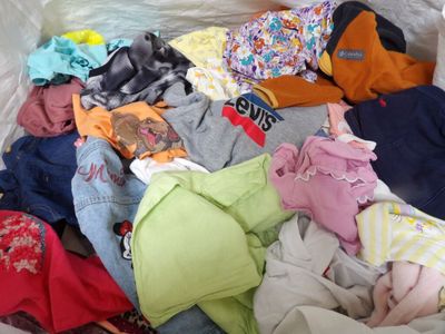 une pile de vêtements posée sur un lit