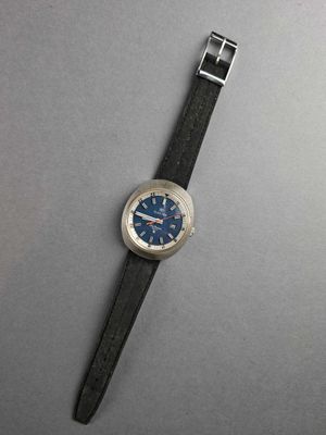 a close up of a watch on a table with a gray background