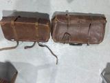 two brown leather bags sitting on a white surface