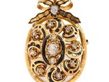 une image représentant une broche en forme d'œuf, en or et diamants, sur fond blanc