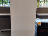 a white refrigerator sitting in a room next to a window