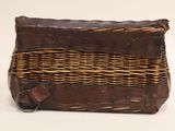 a brown wicker bag with a handle on a white background