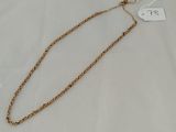 a gold chain necklace with a white tag on it