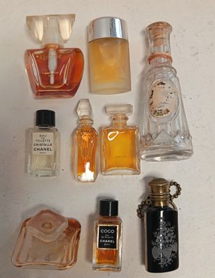 de nombreux flacons de parfum de toutes sortes posés sur une surface blanche