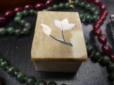 a wooden box with a flower on it on a table