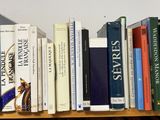 many books that are on a wooden shelf