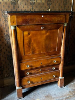 une armoire en bois surmontée d'un tiroir, dans une pièce