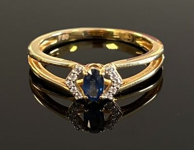 an image of a blue sapphire and diamond ring on a black surface