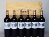 six bouteilles de vin rouge sont posées devant une caisse en bois