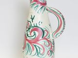 a white vase with a pink and green design on it