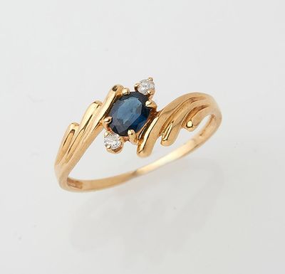a close up of a gold ring with a sapphire and diamonds