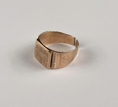 gros plan d'une bague en or sur une surface blanche