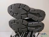 the soles of a pair of black and white running shoes