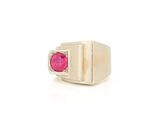 a close up of a ring with a ruby stone in it