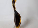 a glass sculpture of a bird sitting on top of a clear base