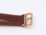 brown leather watch strap with gold buckle on white background