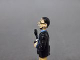 figurine of a man in a black suit with a gun in his hand