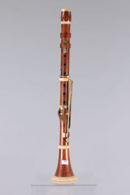 a close up of a wooden bassoon on a clear surface