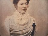 portrait of a woman in a white dress with a black bow