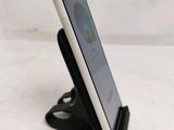 a close up of a cell phone on a stand on a table