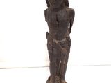 l'image d'une statue de femme debout sur un socle en bois