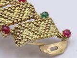 gold bracelet with red, green, and blue stones on a white surface