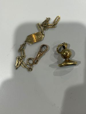two pieces of jewelry sitting on a white surface
