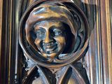 carved wood carving of a man ' s face on the door of a building