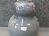 a blue vase sitting on a table with a tag on it