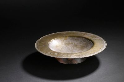 an image of a silver bowl sitting on a black surface