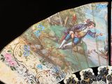 un éventail avec un tableau posé sur une table