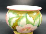 a vase with a flower painted on it on a table