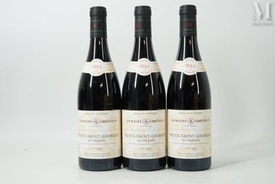 trois bouteilles de vin sont alignées sur une surface blanche
