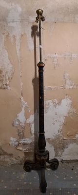 a black pole with a light on it in the corner of a room