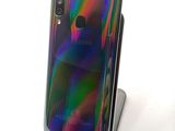 a close up of a cell phone on a stand on a white surface