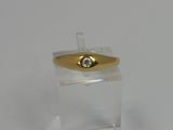 a gold ring with a diamond on top of a clear box