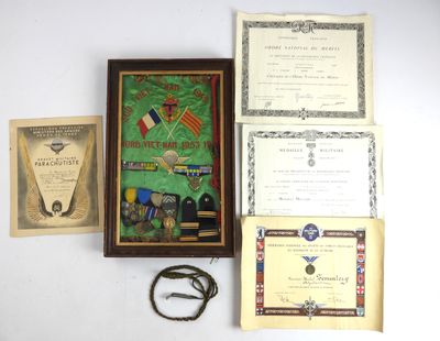 Plusieurs objets sont disposés sur une surface blanche, notamment une photo encadrée, un certificat et une paire de ciseaux.