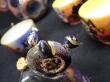 a close up of a vase with a bird on it