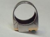 gros plan d'une bague en argent sur une surface blanche