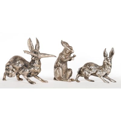 a pair of silver plated rabbit figurines on a white background
