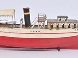 une maquette de bateau rouge et blanche posée sur une surface blanche