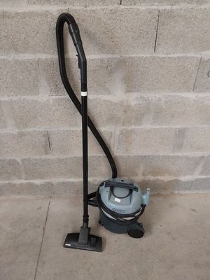 a vacuum that is on the ground next to a brick wall