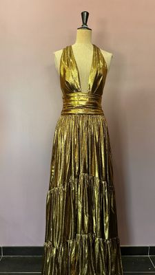 une robe dorée sur un mannequin, un mannequin, un mannequin, un mannequin, un mannequin, un mannequin, un mannequin, un mannequin, un mannequin