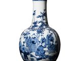 un vase bleu et blanc posé sur une surface blanche
