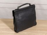 the black leather briefcase is sitting on a wooden table