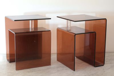 une paire de tables d'appoint en verre marron posées sur un sol blanc